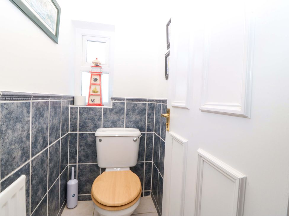 A bathroom with a toilet and window at Bryniau Morfa Nefyn