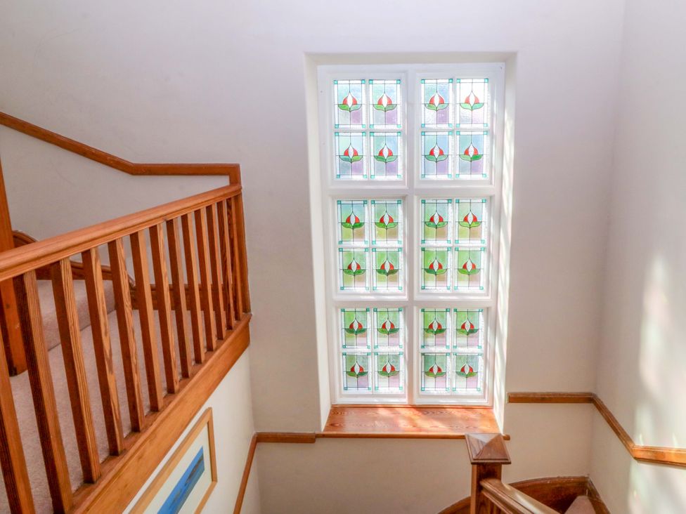 A staircase with stained glass window at Bryniau in Morfa Nefyn