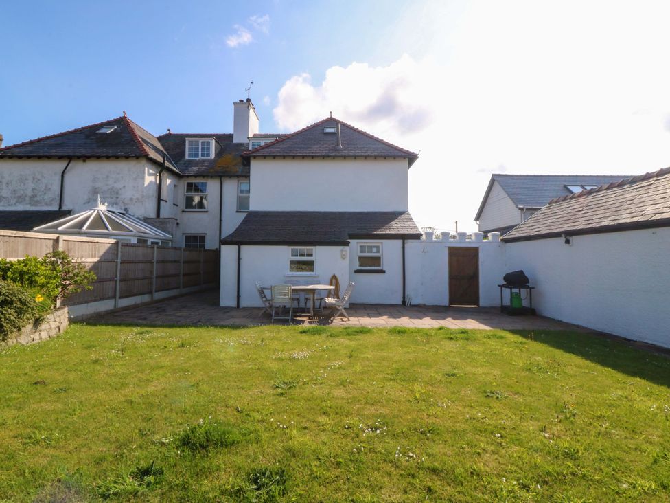 A garden with a patio and table at Bryniau in Morfa Nefyn