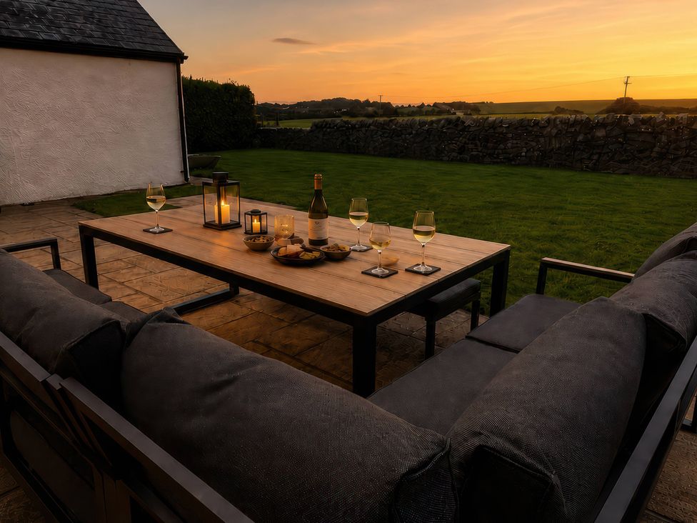 An outdoor seating area with drinks and snacks at Bryniau, Morfa Nefyn