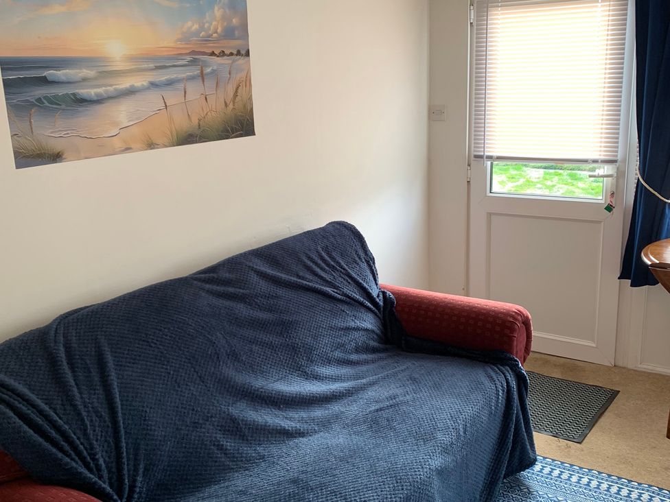 A living room with a sofa covered in a blanket at 187 Atlantic Bays, Tregolds