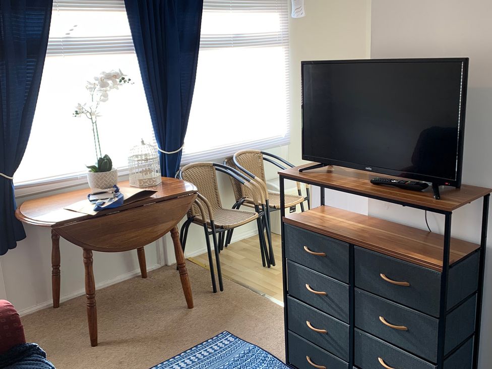 A living room with a television and a table at 187 Atlantic Bays Tregolds