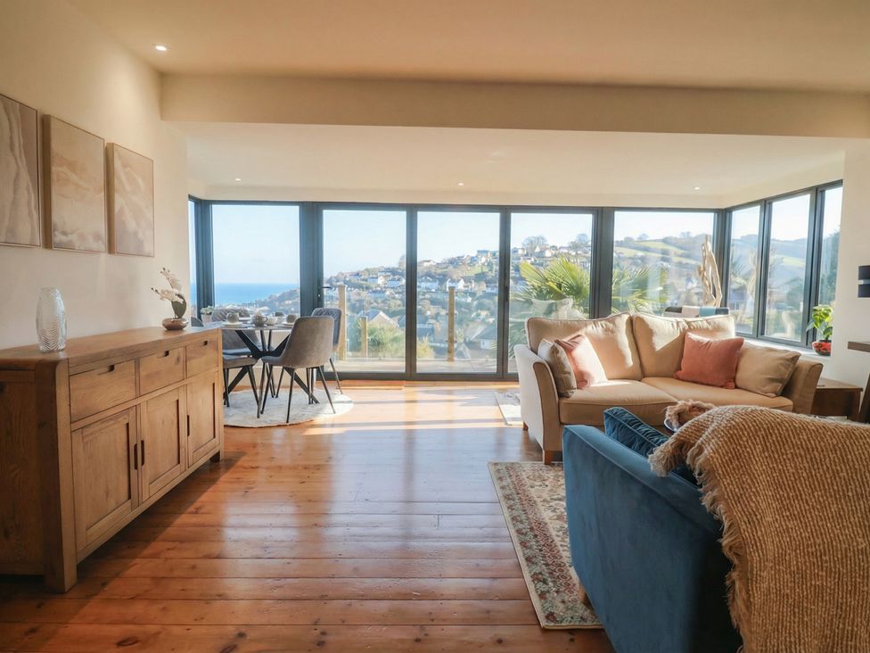 A living room with large windows overlooking the sea at Devona in Beer