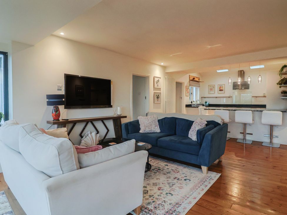 A living room with a sofa and television at Devona in Beer