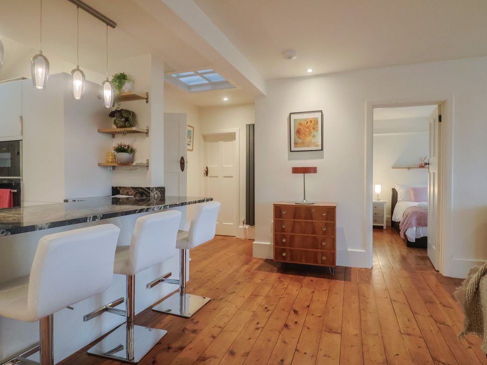 A kitchen with bar stools and a console table at Devona in Beer