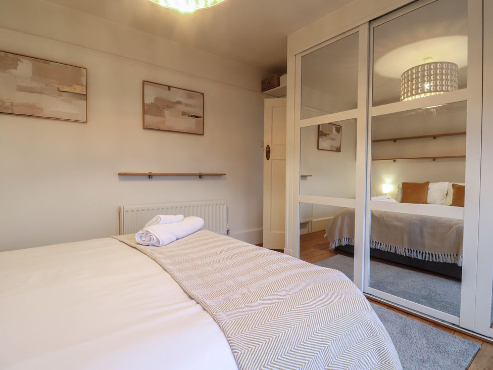 A bedroom with a bed and wardrobe at Devona in Beer