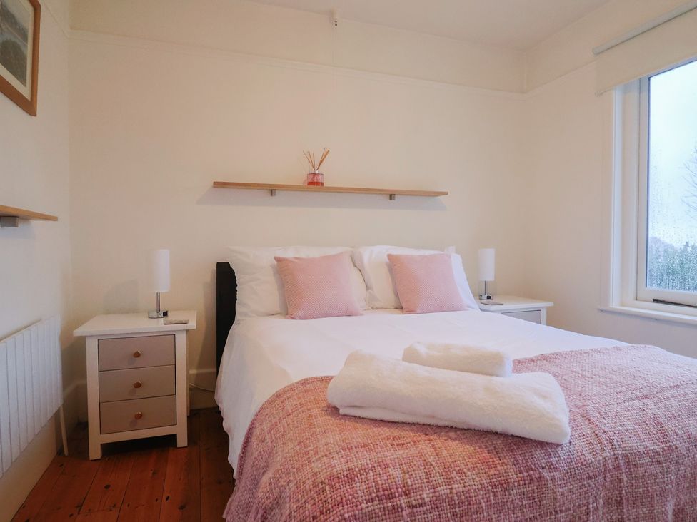 A bedroom with a bed and nightstand at Devona in Beer