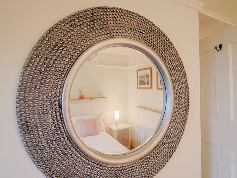 A bedroom with a mirror and bed at Devona in Beer