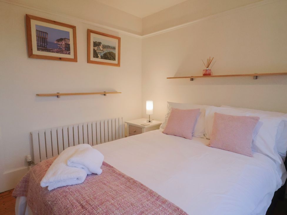 A bedroom with a bed and nightstand at Devona in Beer