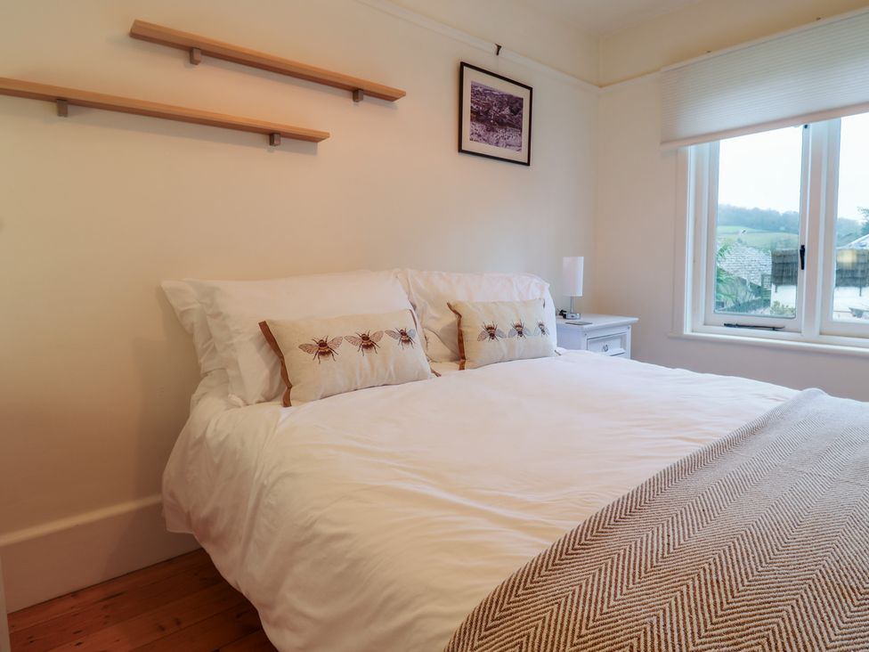 A bedroom with a bed and bedside table at Devona in Beer