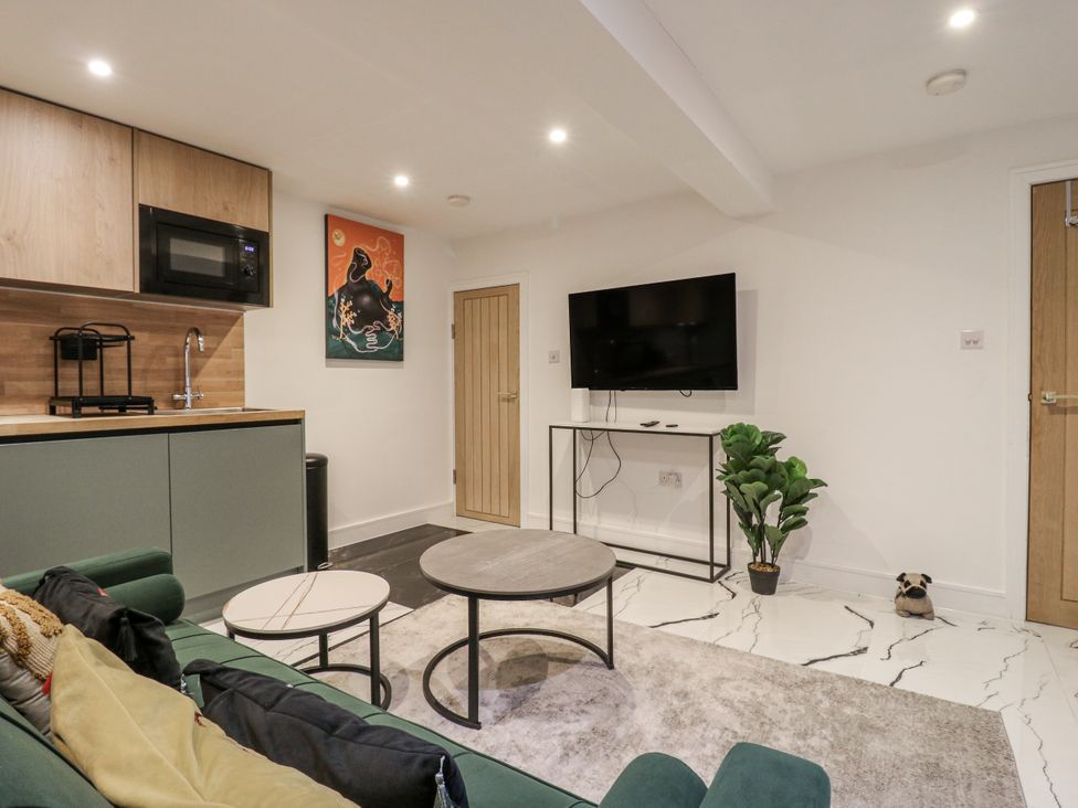 A living room with a sofa, coffee table, and television at 2A Ruby Street, Southwark, London