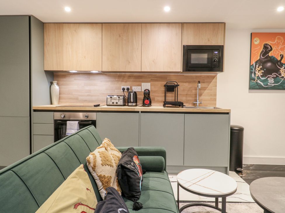 A kitchen with appliances and seating at 2A Ruby Street Southwark, London