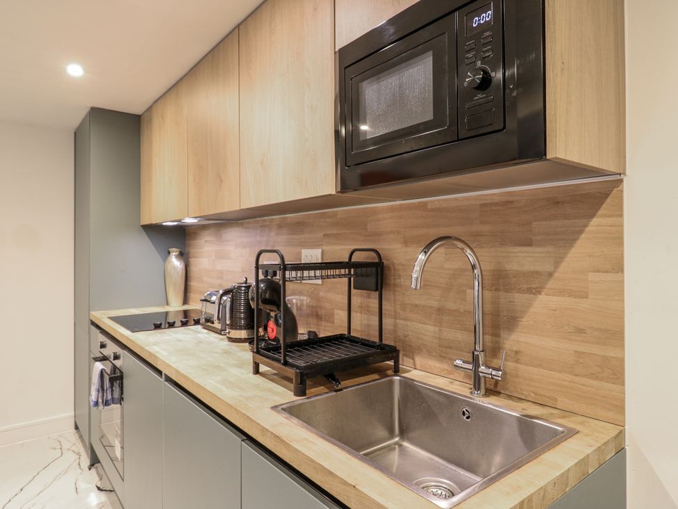 A kitchen with a sink and microwave at 2A Ruby Street Southwark, London