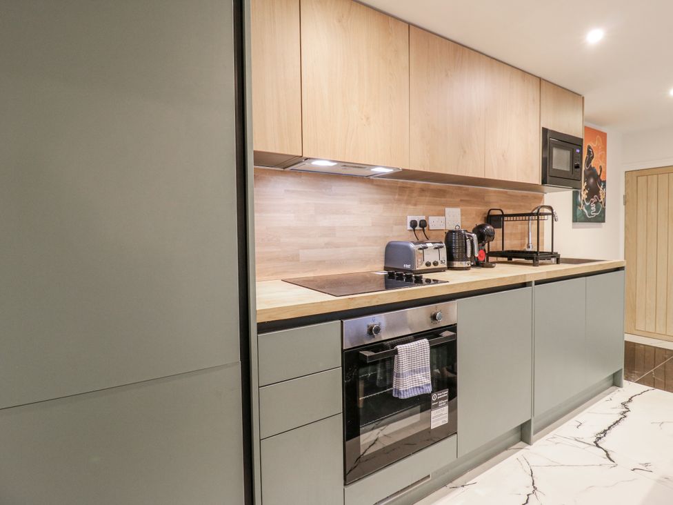 A kitchen with appliances and cabinets at 2A Ruby Street Southwark, London