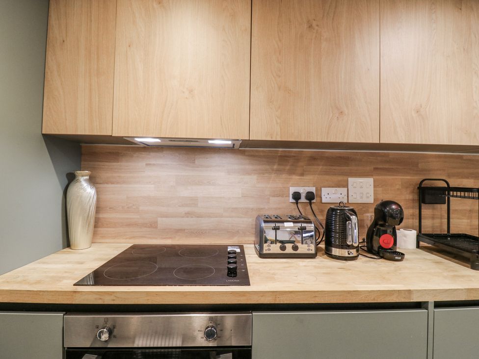 A kitchen with a cooker, toaster, kettle, and coffee machine at 2A Ruby Street, Southwark, London