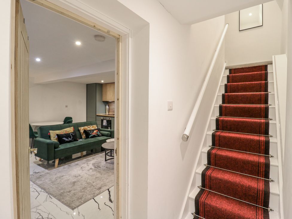 A staircase leading to a living room with a sofa and a dining table at 2A Ruby Street Southwark, London