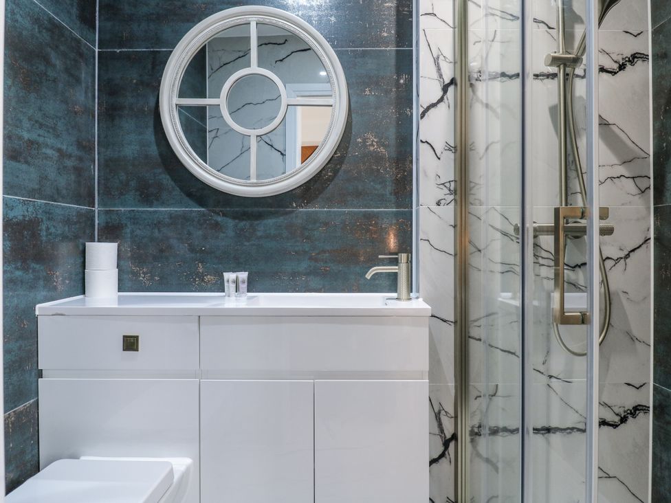 A bathroom with a mirror, sink, toilet, and shower at 2A Ruby Street, Southwark, London