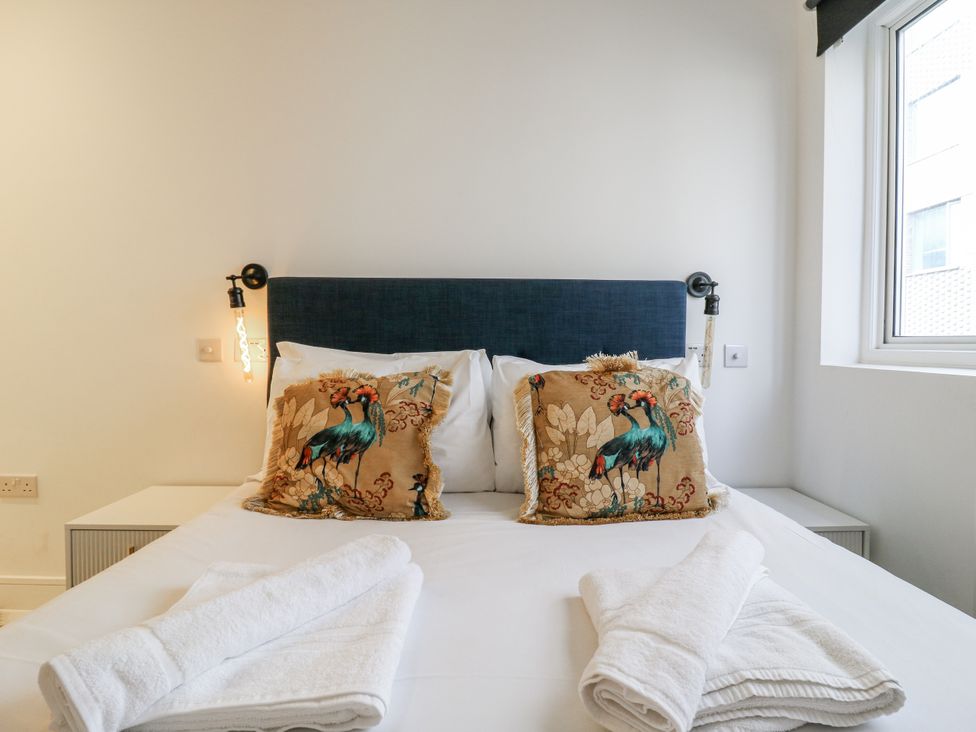 A bedroom with a bed and decorative pillows at 2A Ruby Street in Southwark, London