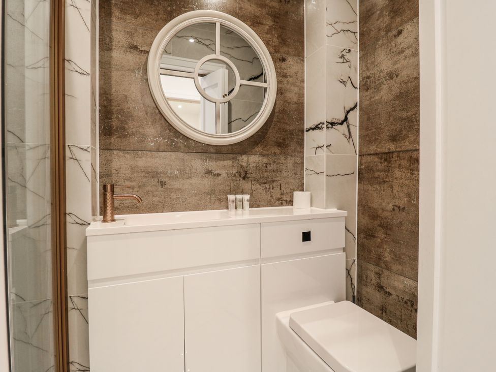 A bathroom with a mirror, sink, cabinet, and toilet at 2A Ruby Street Southwark, London