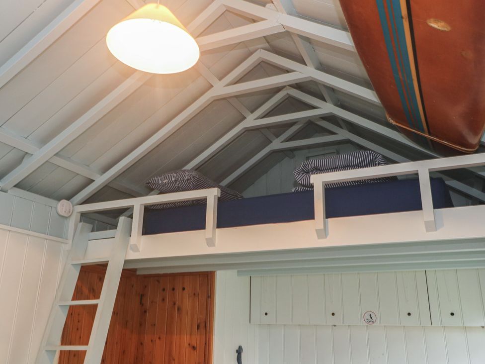 A loft with a bed and a ladder at Pleasans in Hayle