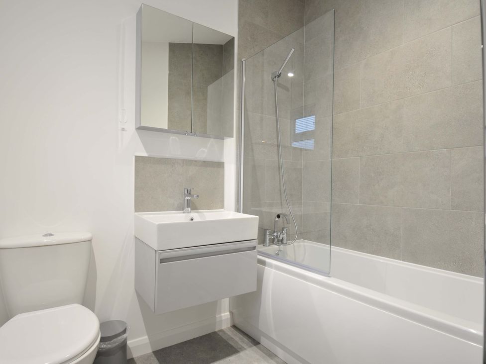 A bathroom with a toilet, sink, mirror, and bathtub at 20 Meadow Retreat in Dobwalls