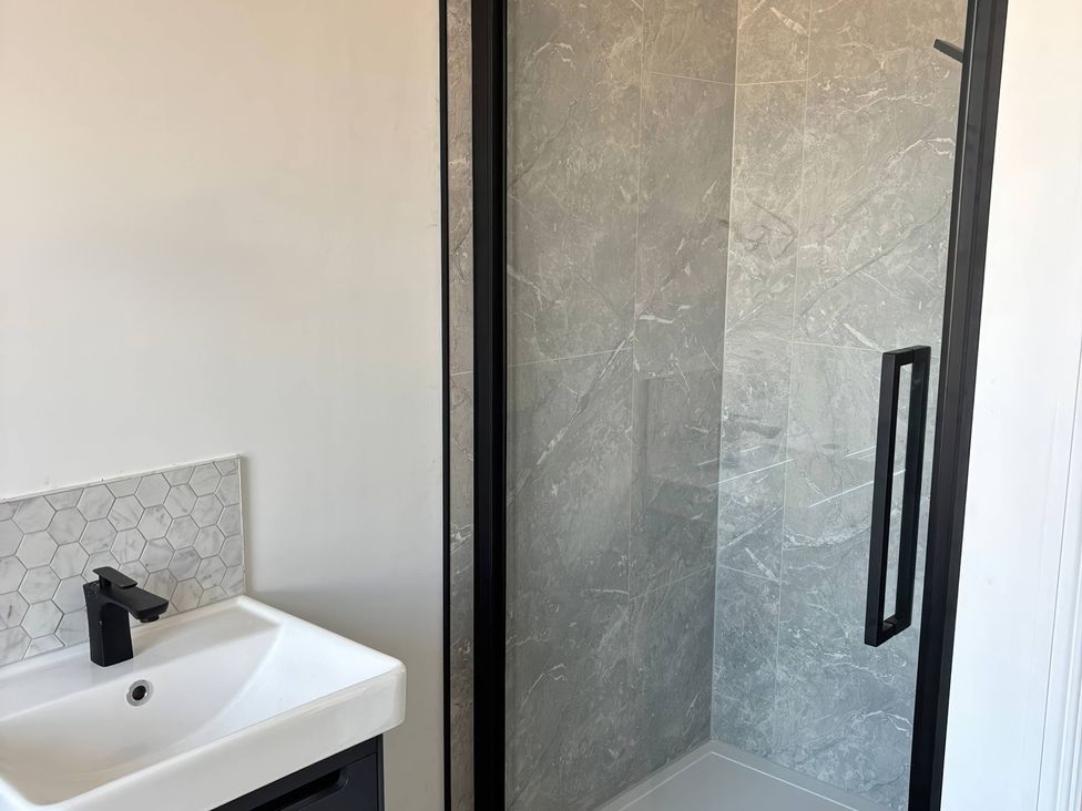 A bathroom with a sink and shower at Holt Hall - First Floor Apartment in Matlock