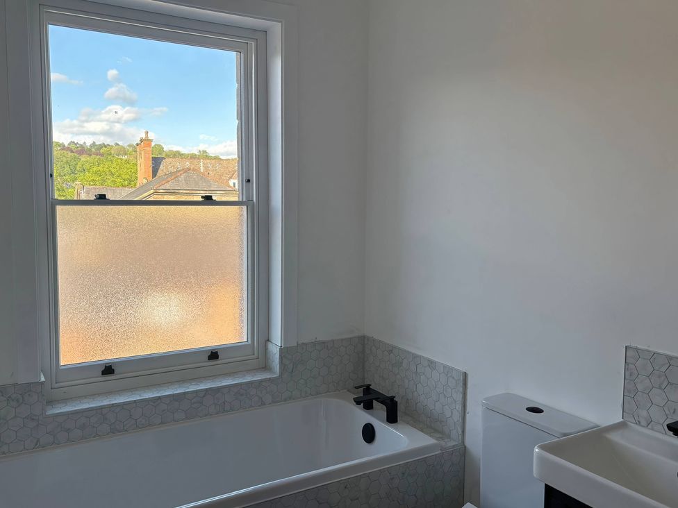 A bathroom with a bathtub, toilet, and sink at Holt Hall - First Floor Apartment Matlock