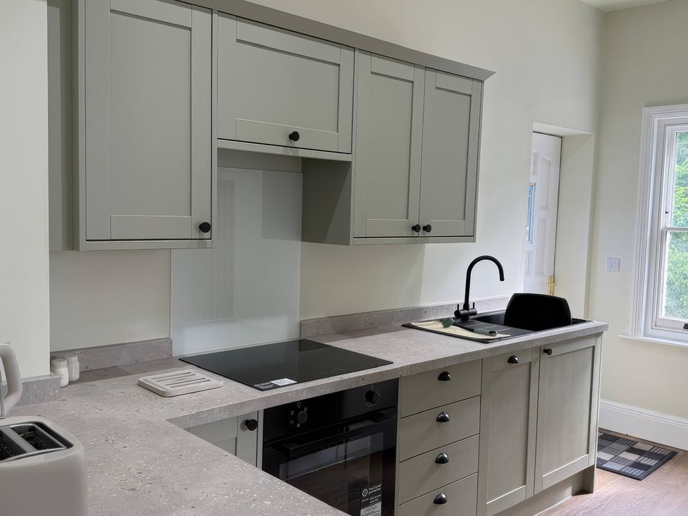 A kitchen with cabinetry and appliances at Holt Hall - First Floor Apartment Matlock
