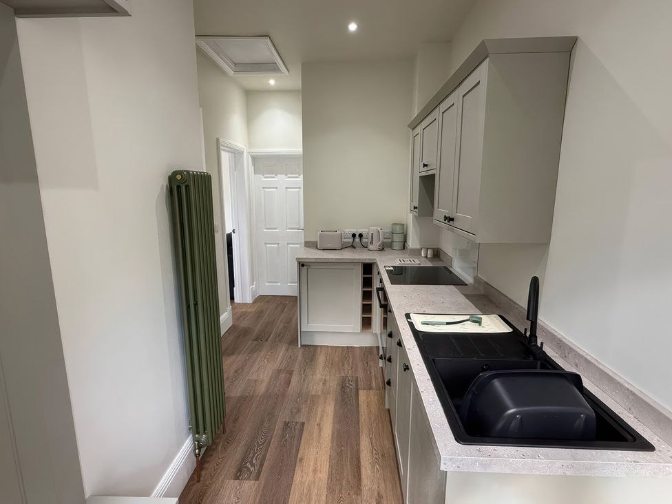 A kitchen with cabinets and sink at Holt Hall - First Floor Apartment Matlock