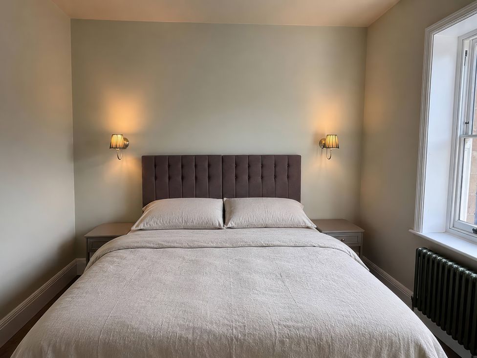 A bedroom with a bed and nightstand at Holt Hall - First Floor Apartment in Matlock