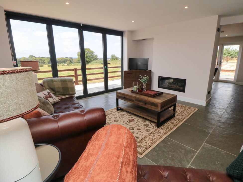 A living room with sliding glass doors and a coffee table at Westholme Lodge in Thirsk