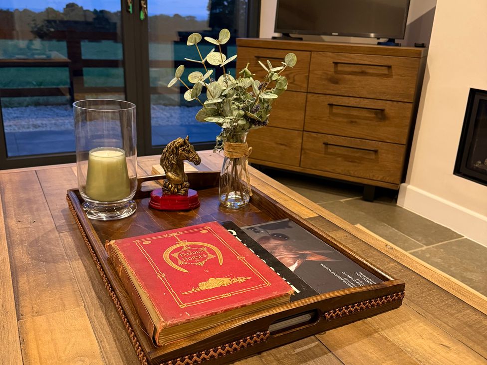 A coffee table with a book, candle, and vase at Westholme Country Lodge in Thirsk