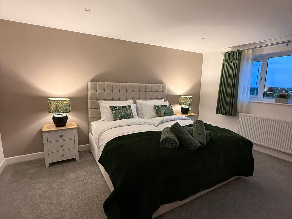 A bedroom with a bed and lamps beside it at Westholme Country Lodge in Thirsk