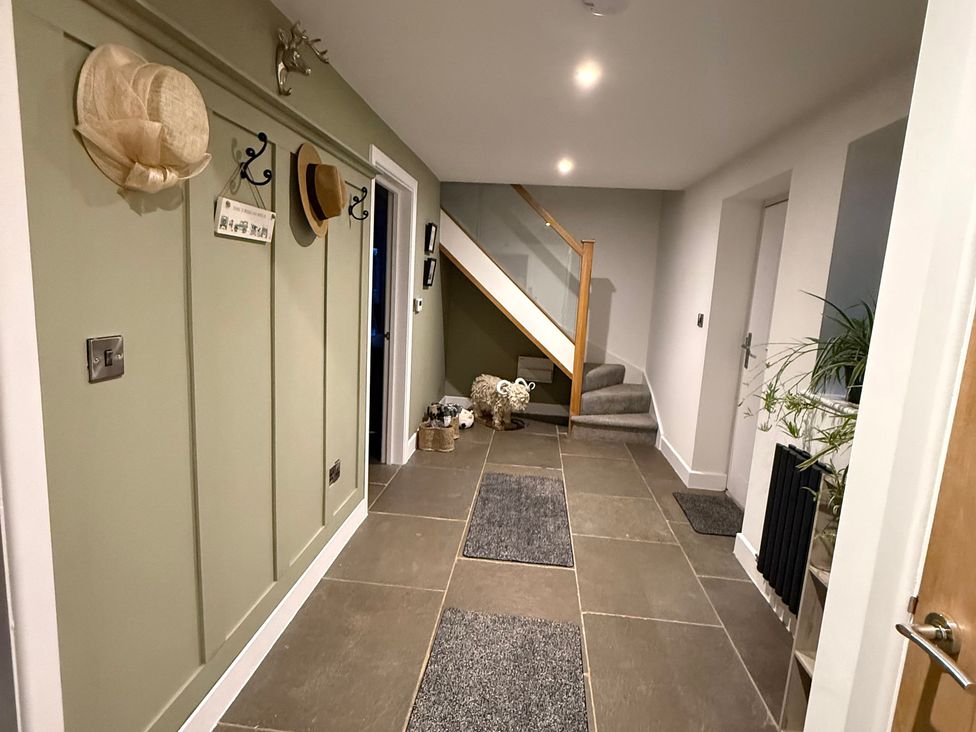 A hallway with coat hooks and hats at Westholme Country Lodge in Thirsk