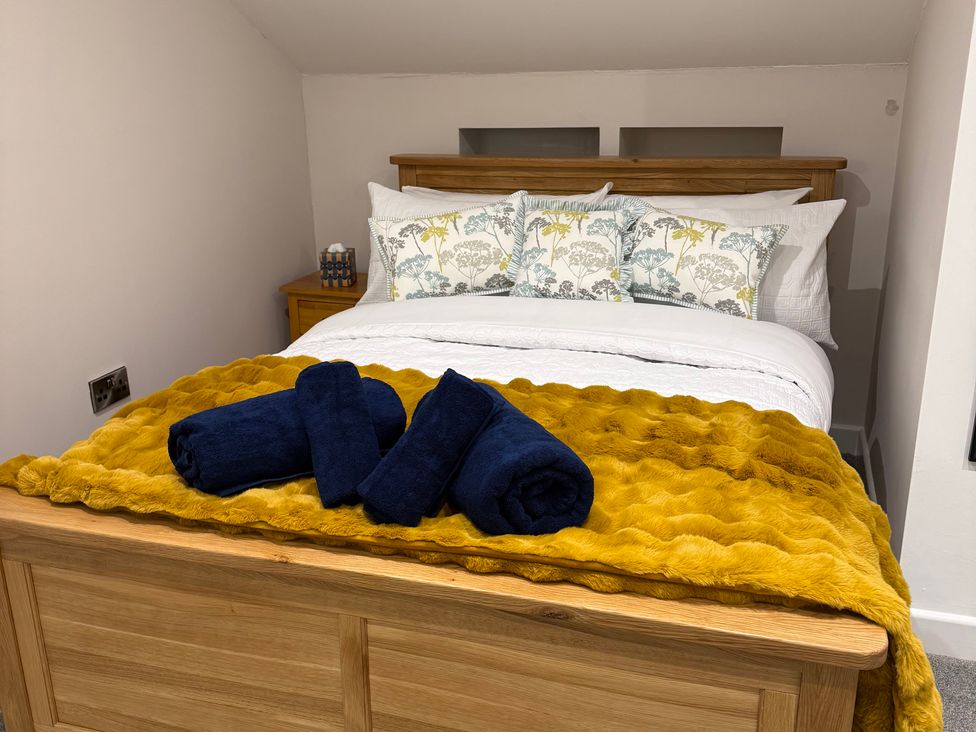 A bedroom with a bed, pillows, and towels at Westholme Country Lodge in Thirsk