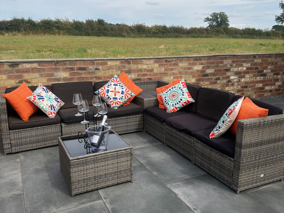 An outdoor seating area with sofas and a glass table at Westholme Country Lodge Thirsk