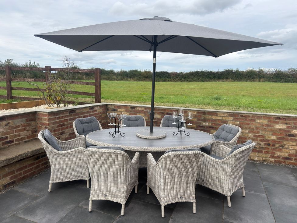 A patio with a table and chairs under an umbrella at Westholme Country Lodge Thirsk