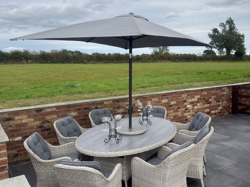 An outdoor dining area with a table and chairs at Westholme Country Lodge Thirsk