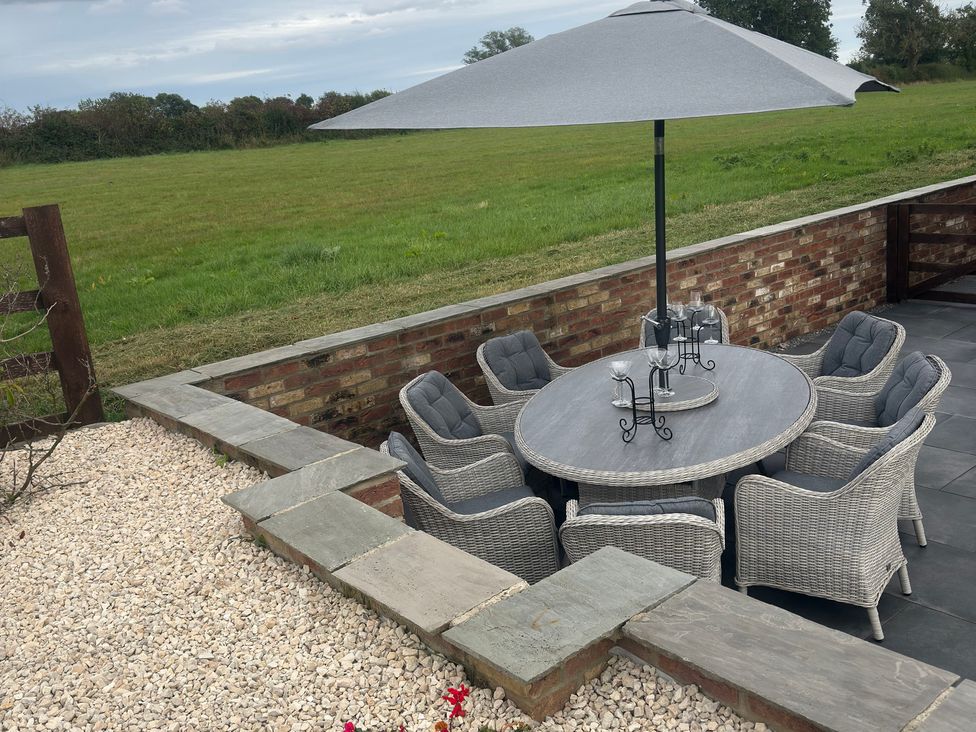 An outdoor dining area with a round table and chairs at Westholme Country Lodge Thirsk