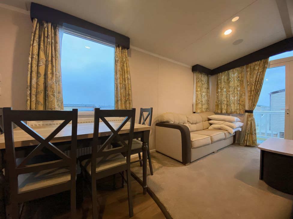 A living room with a dining table and chairs at Thameside in Allhallows