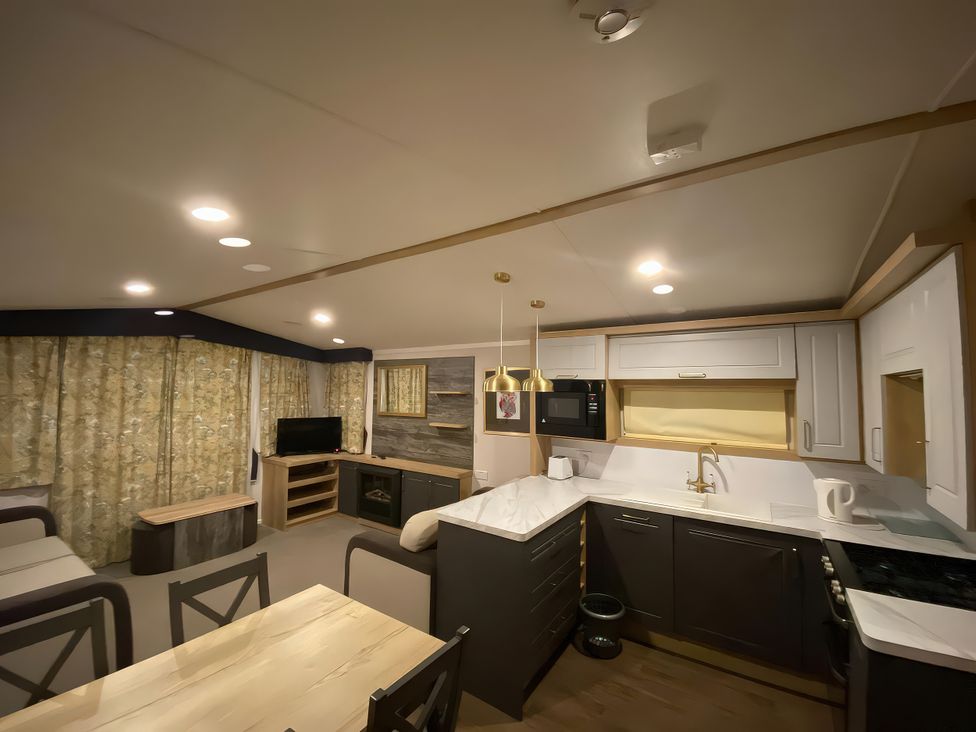 A kitchen with dining table and chairs at Thameside in Allhallows