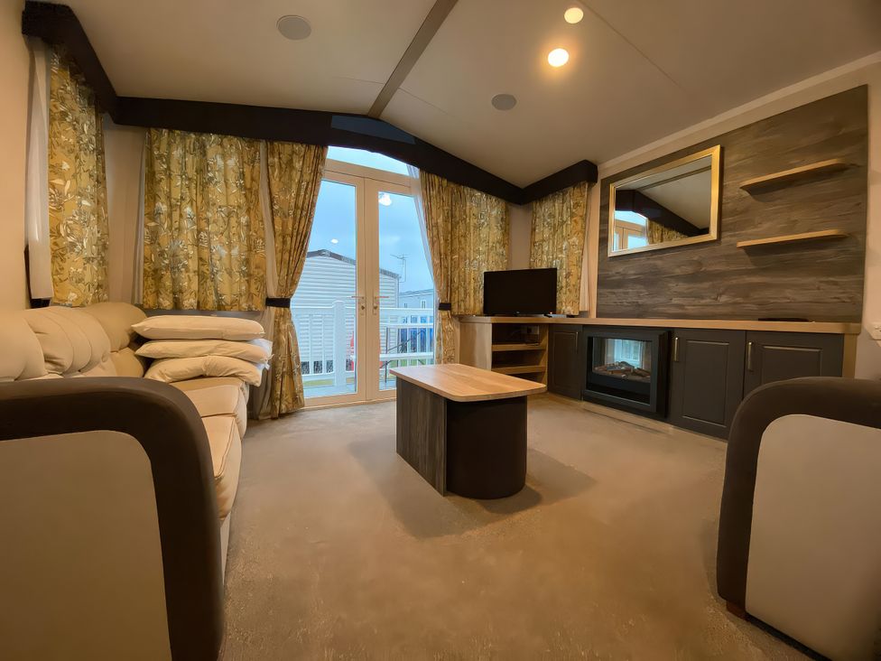 A living room with a sofa and television at Thameside in Allhallows