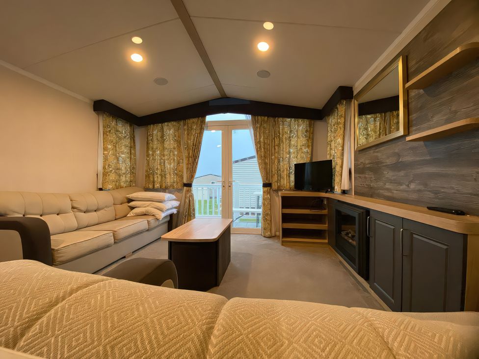 A living room with a sofa and television at Thameside in Allhallows