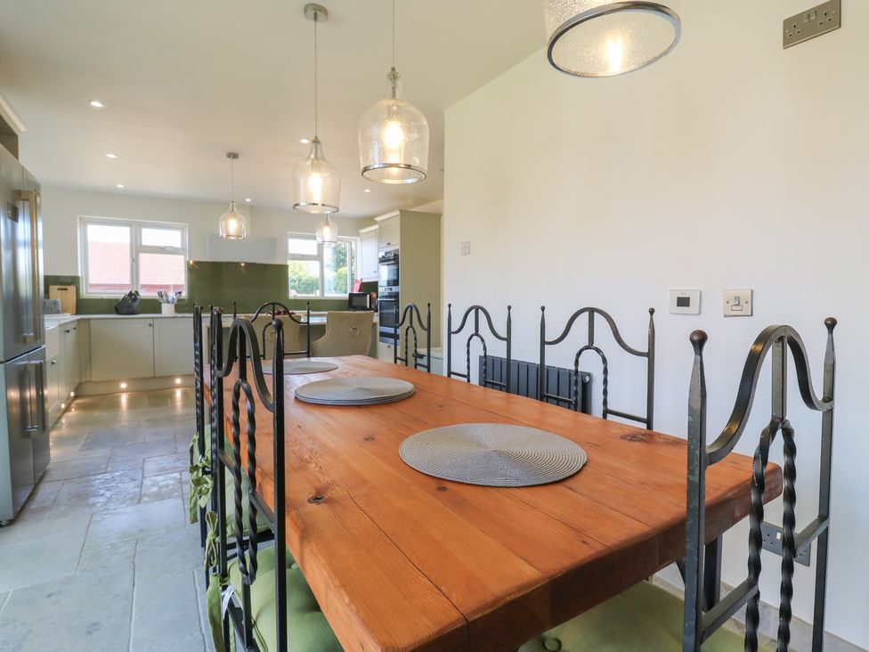 A kitchen with a dining table and chairs at Panel Place near Pett
