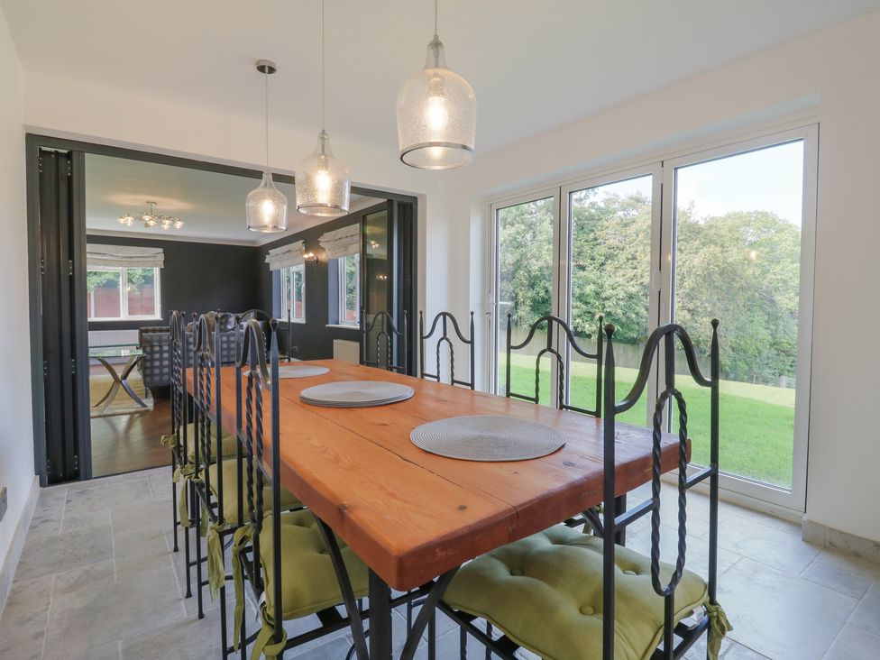 A dining room with a table and chairs at Panel Place near Pett