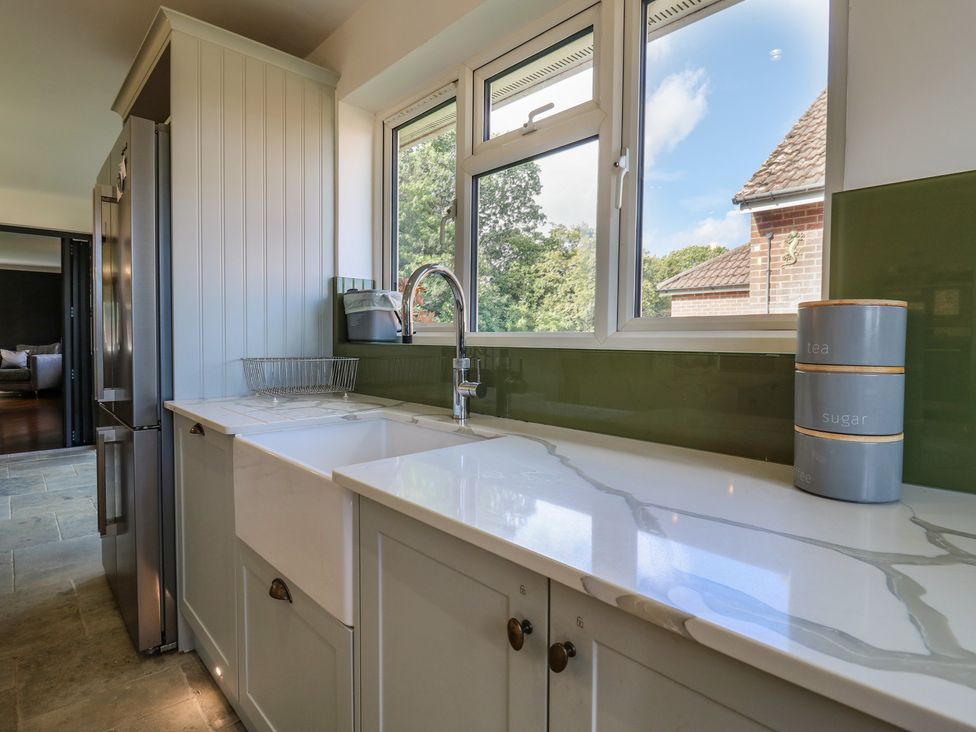 A kitchen with sink and refrigerator at Panel Place near Pett
