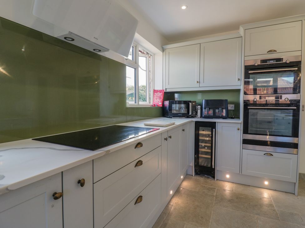 A kitchen with cabinets, countertop, and appliances at Panel Place near Pett
