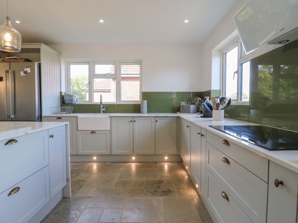 A kitchen with cabinets and a sink at Panel Place near Pett