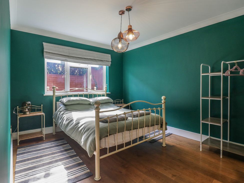 A bedroom with a bed and a shelf at Panel Place near Pett