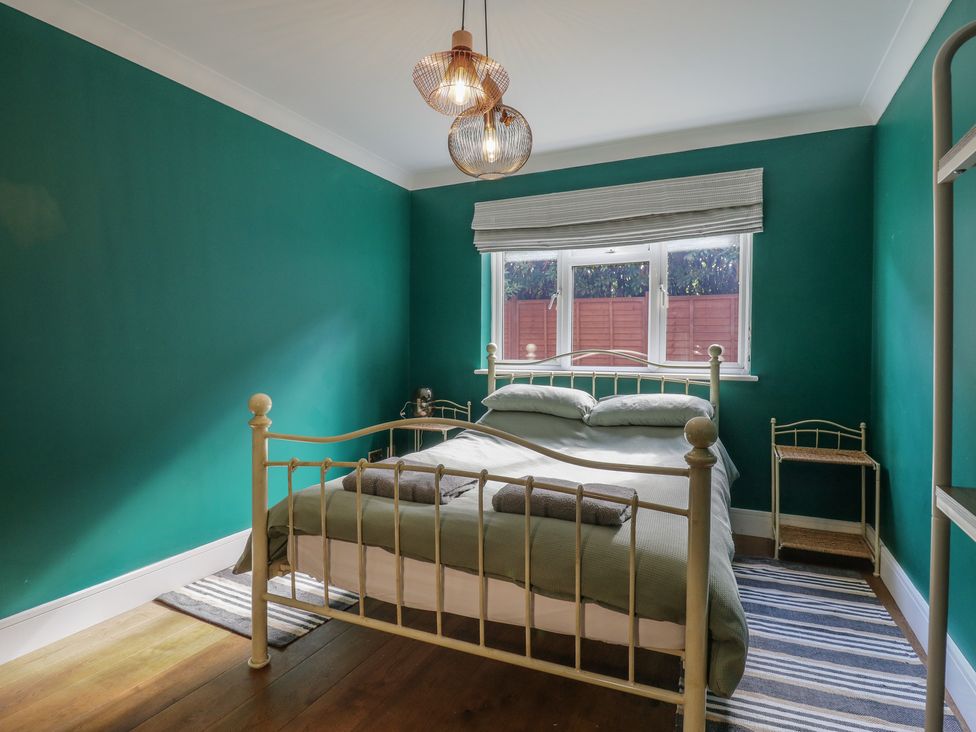 A bedroom with a bed and windows at Panel Place near Pett